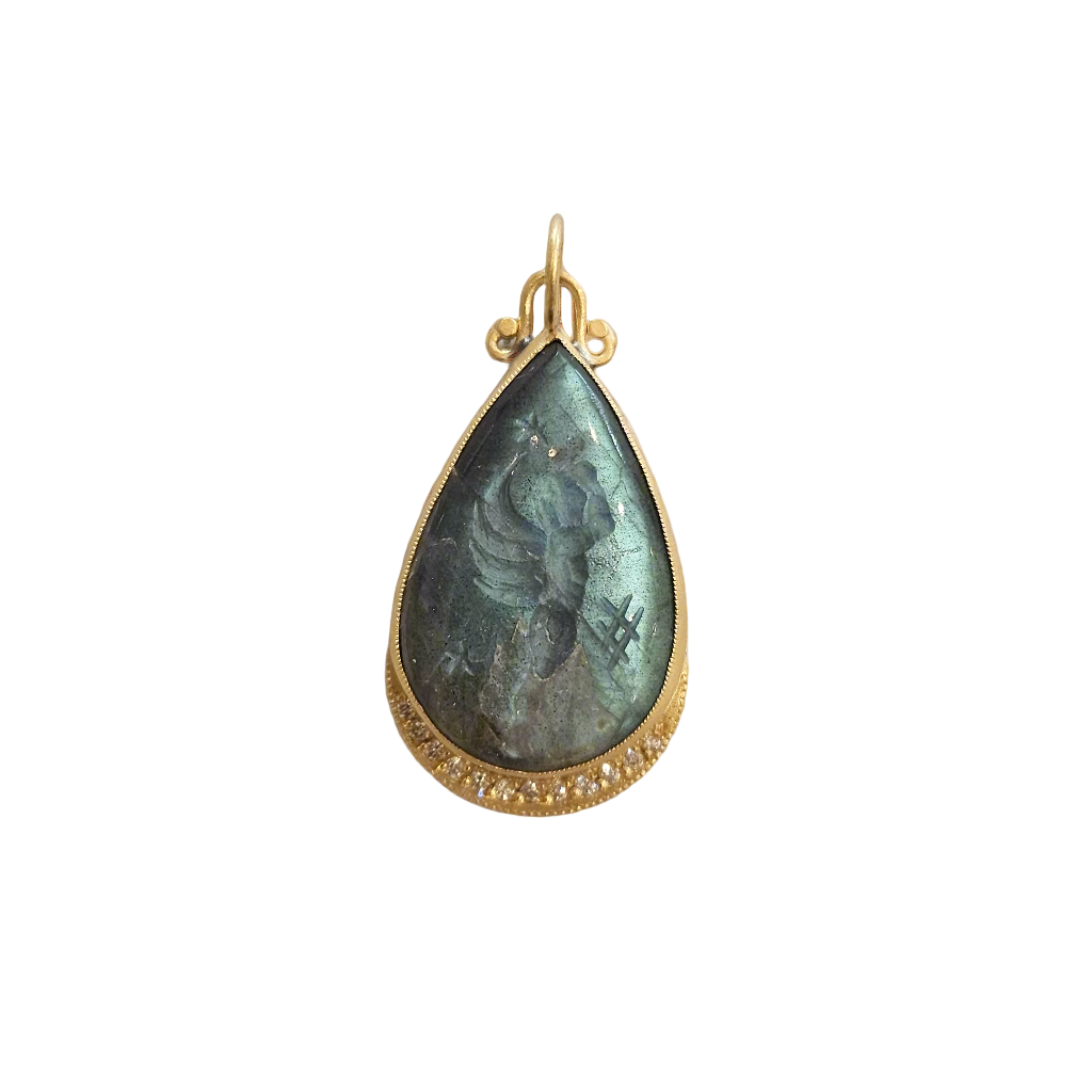 Teardrop-shaped pendant with gold frame and green stone on beige fabric background