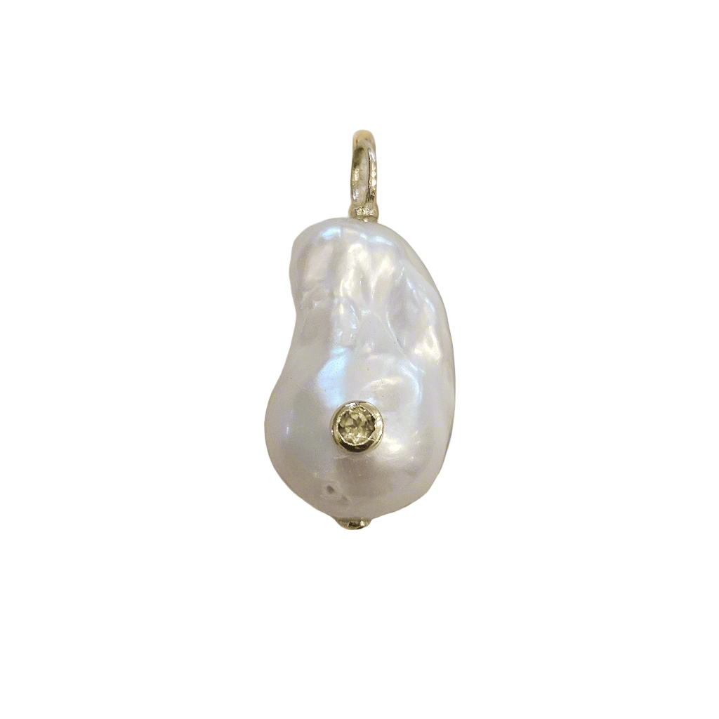 Pearl pendant with a small gemstone on a beige fabric background