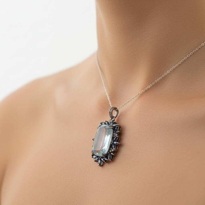 Pendant with a green stone and black accents on a beige fabric background