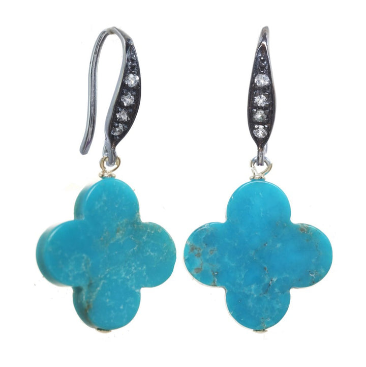 Pair of turquoise flower-shaped earrings with silver hooks on a white background