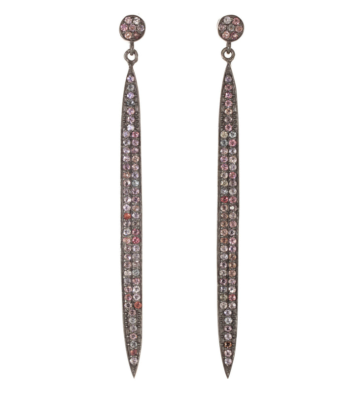 Pair of long, thin earrings with rhinestone embellishments on a white background
