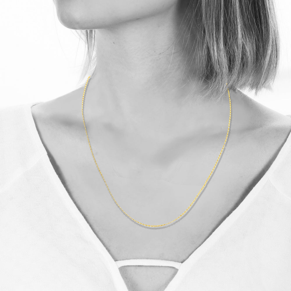 Gold necklace on a mannequin with a white background