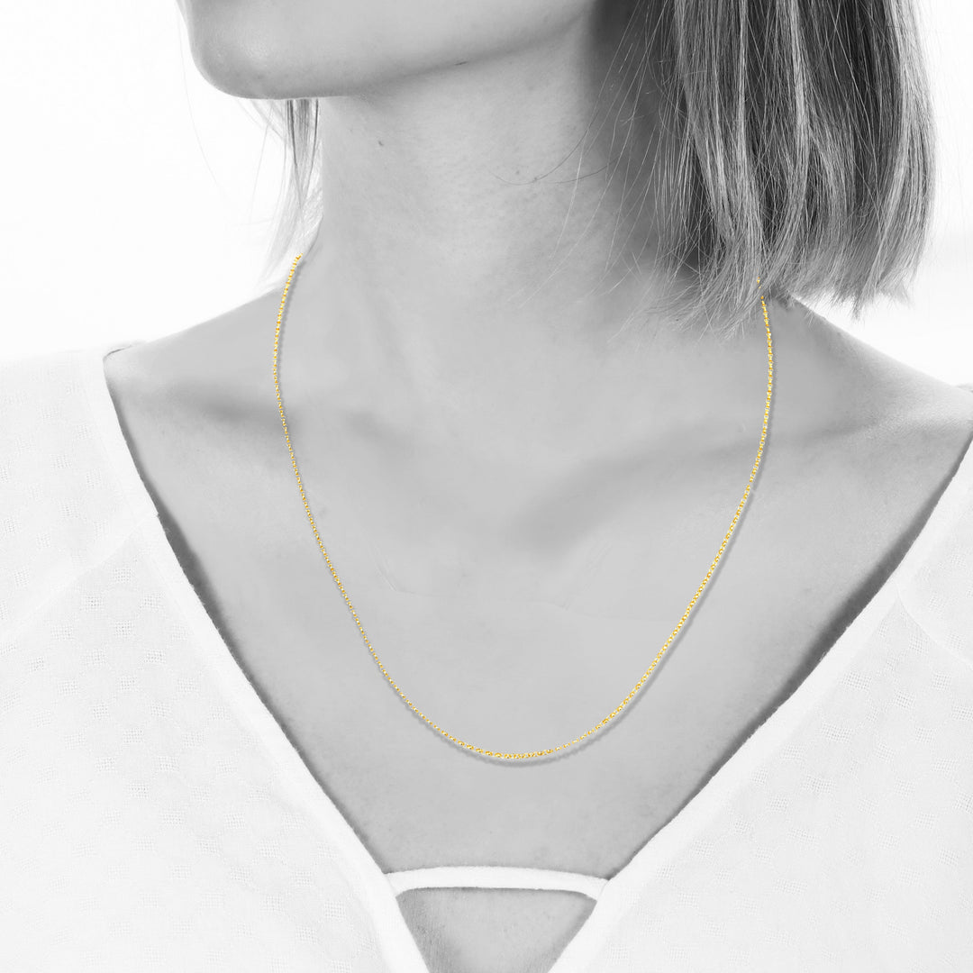 Gold necklace on a mannequin with a white background