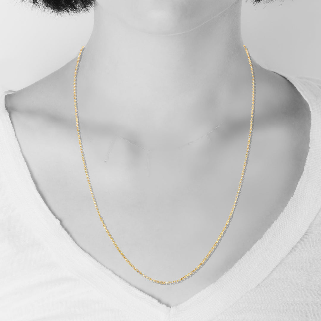 Gold necklace on a mannequin with a plain background
