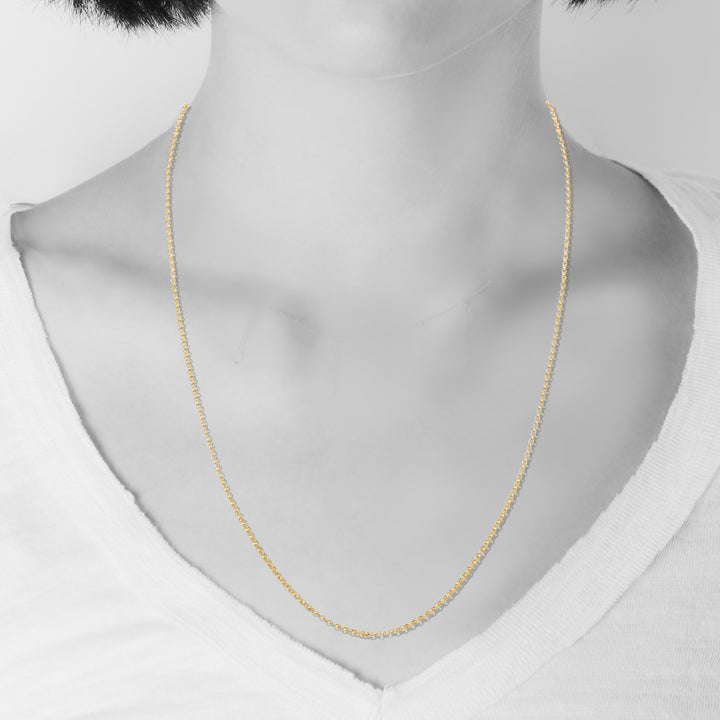 Gold necklace on a mannequin with a plain background