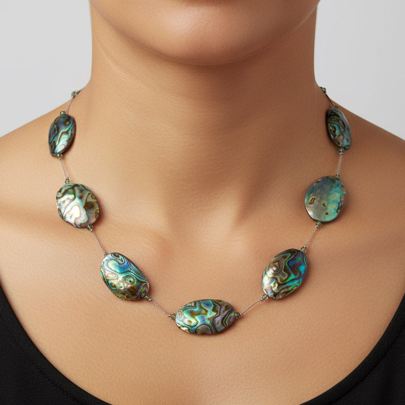 Necklace with abalone shell beads on a white background