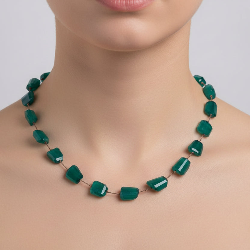 Teal necklace with irregularly shaped beads on a white background