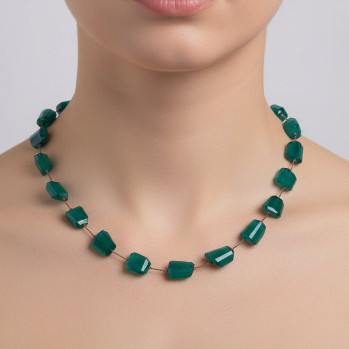 Teal necklace with irregularly shaped beads on a white background
