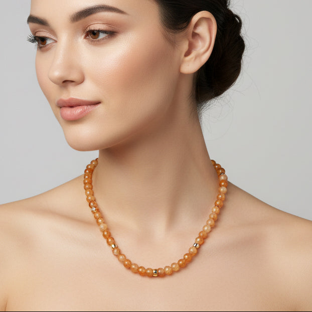 Beaded necklace with orange and beige beads on a white background