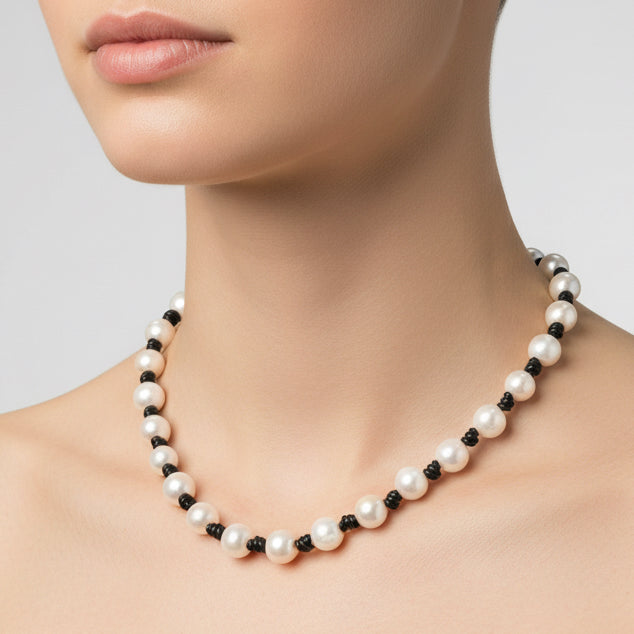 Pearl necklace with black beads on a white background
