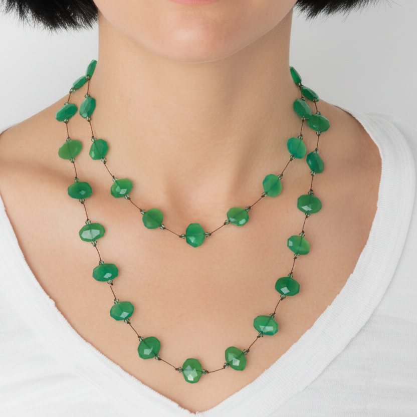 Green beaded necklace on a mannequin with a white background