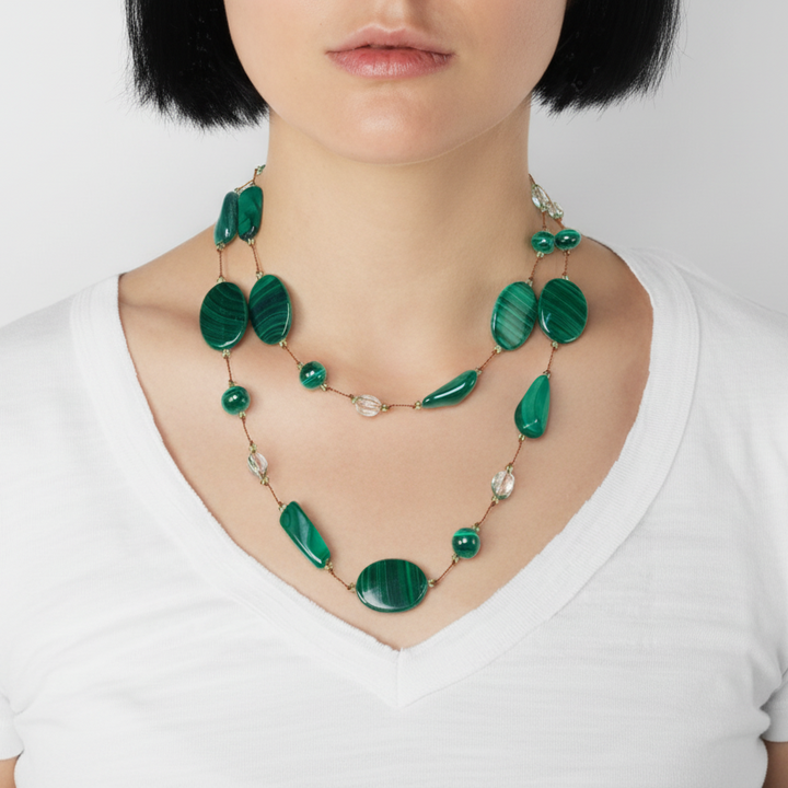 Green beaded necklace on a mannequin with a white background