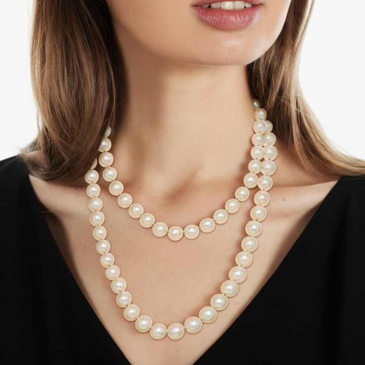 Pearl necklace worn by a person against a black background